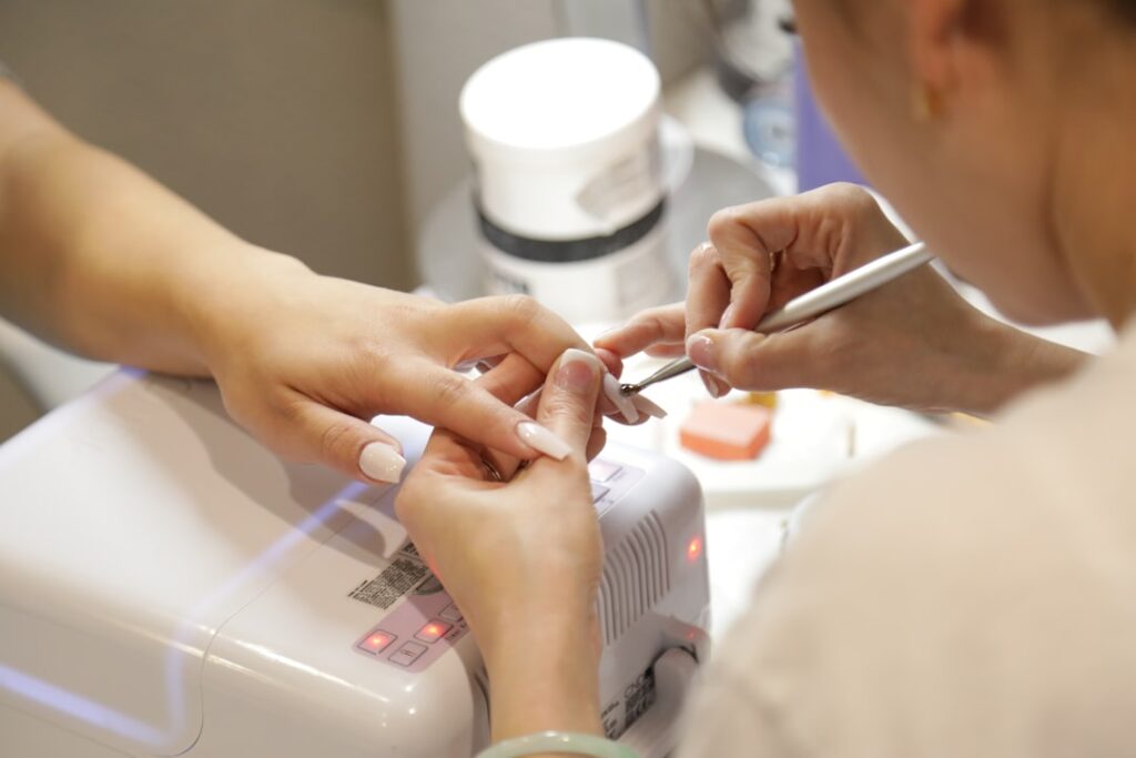 Femme retirant son vernis semi-permanent naturellement sans acétone à la maison