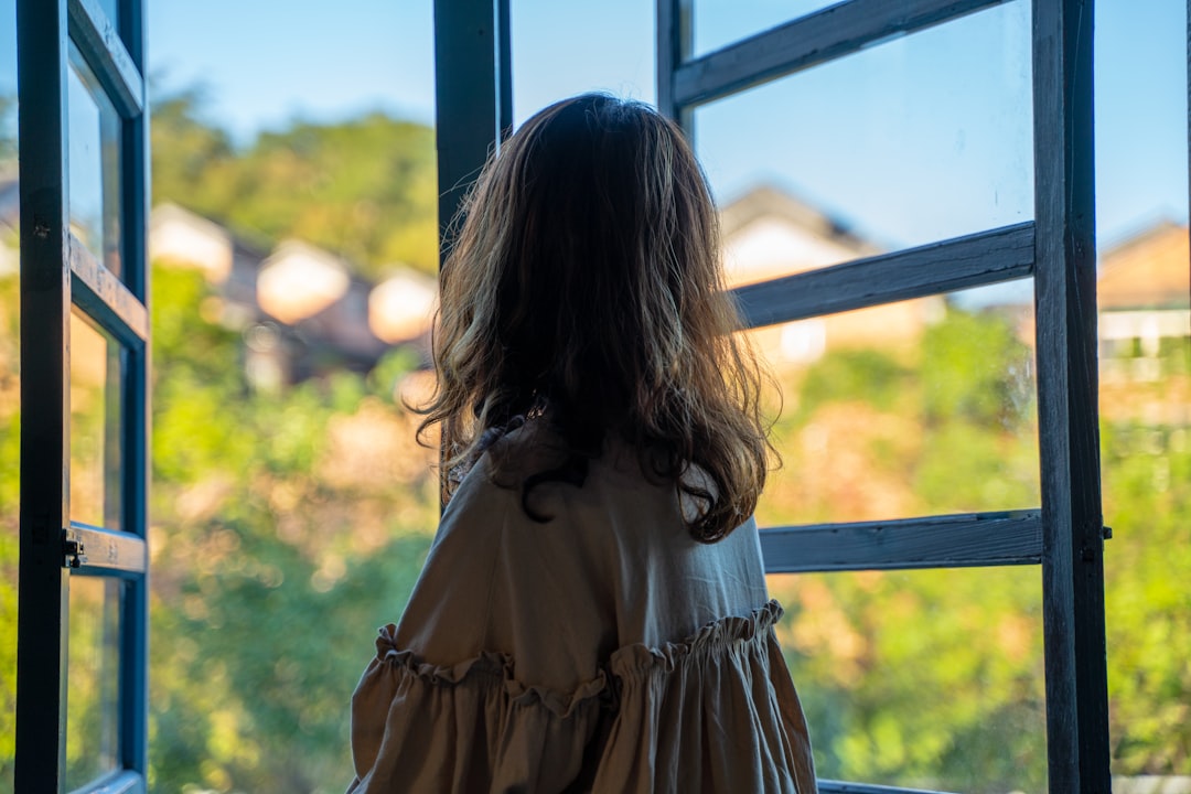 Femme pensive regardant par la fenêtre après une rupture